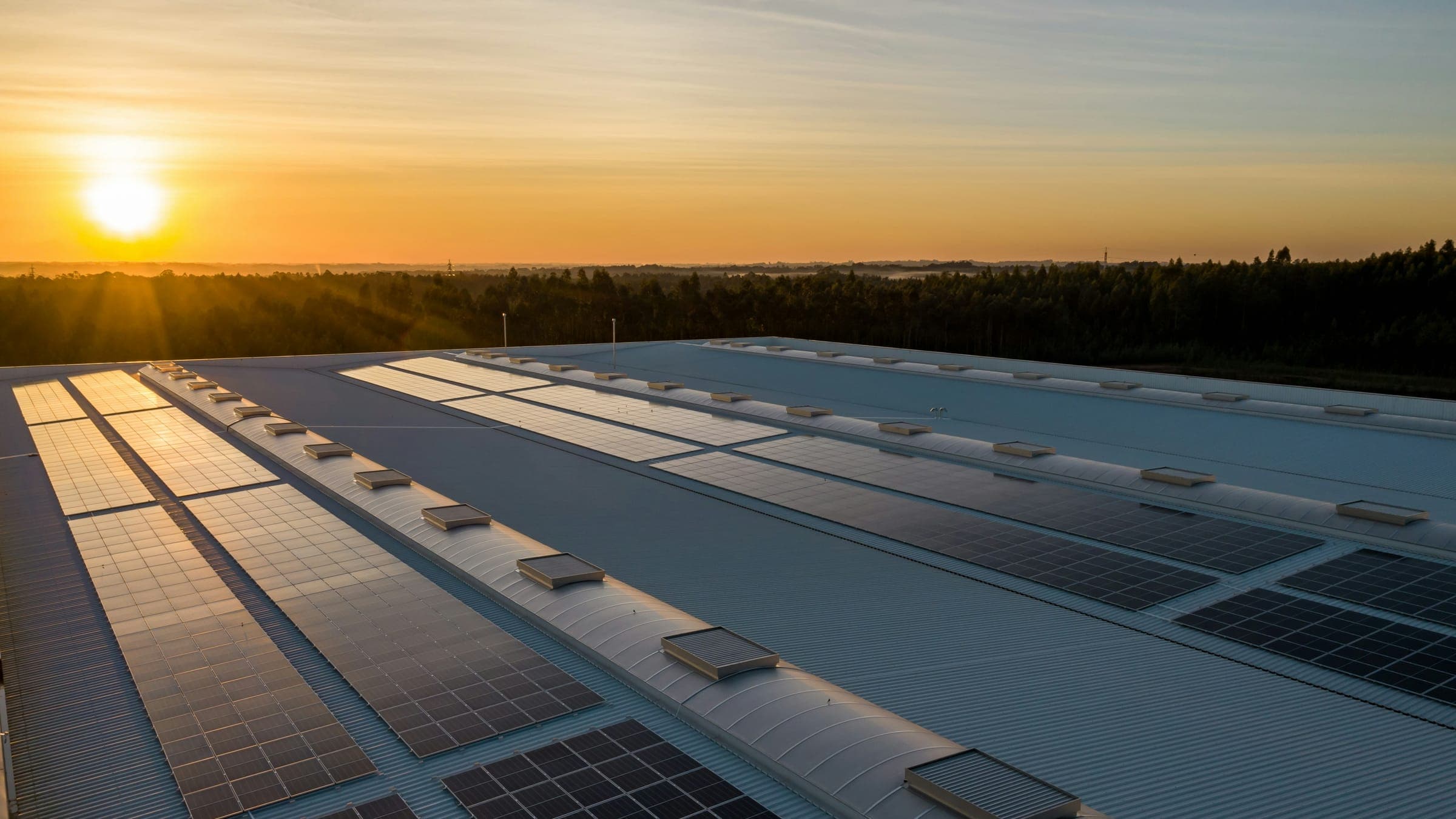 Impianto fotovoltaico su un tetto industriale al tramonto
