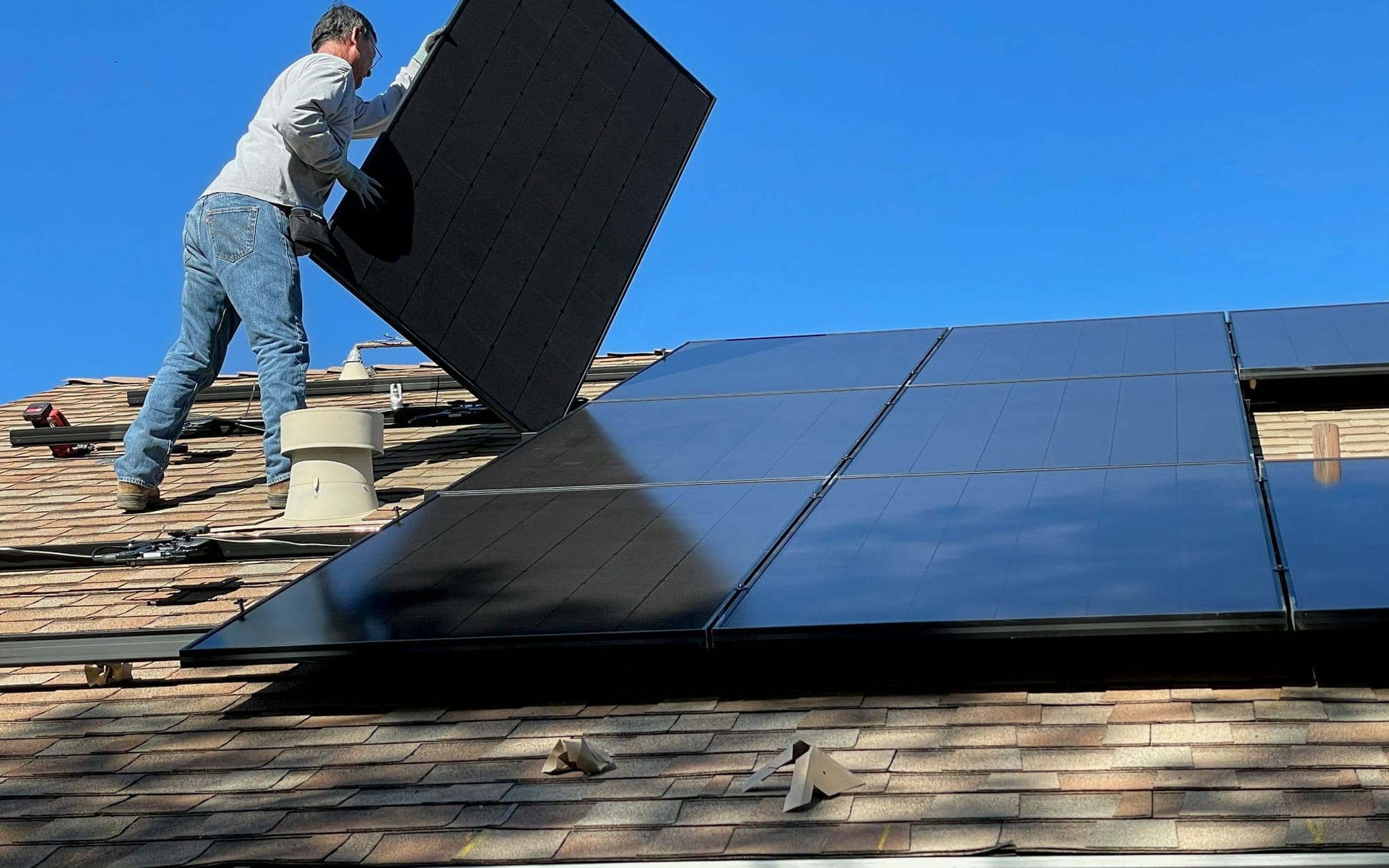 Installatore che posiziona un pannello solare su un tetto